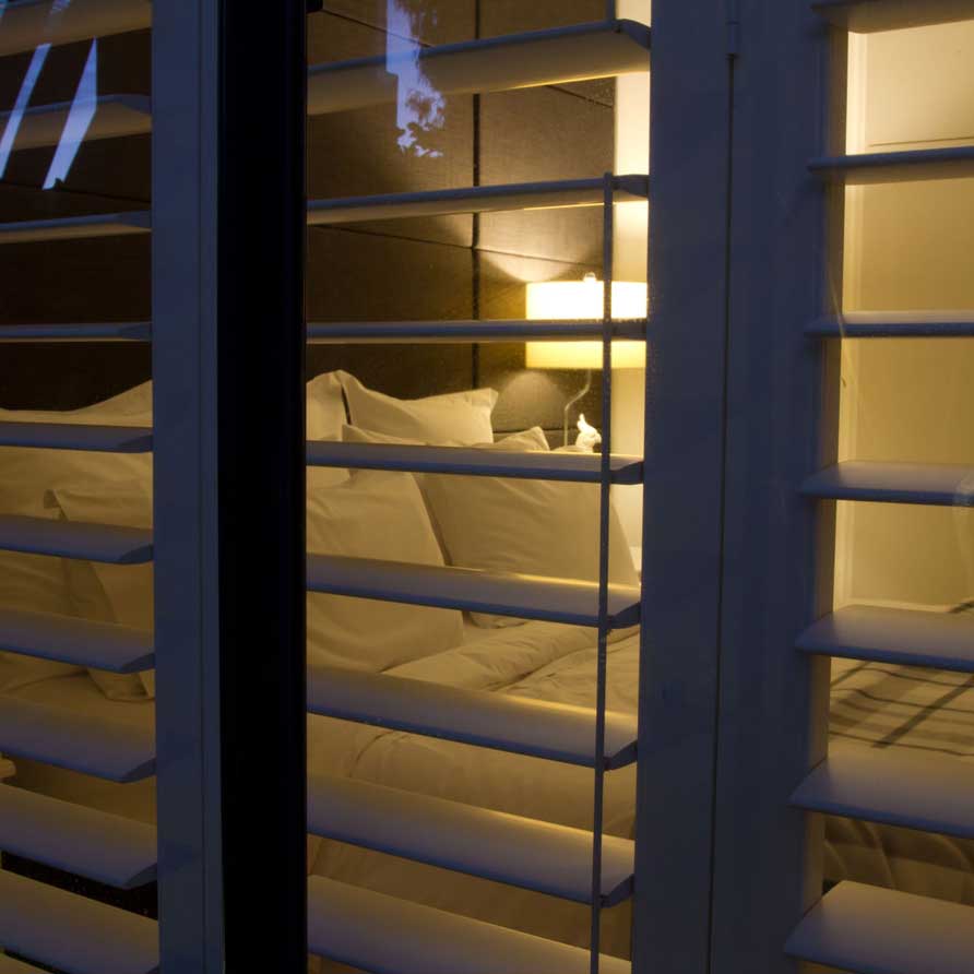 View through shutters of the bedroom of the Parkside Suite