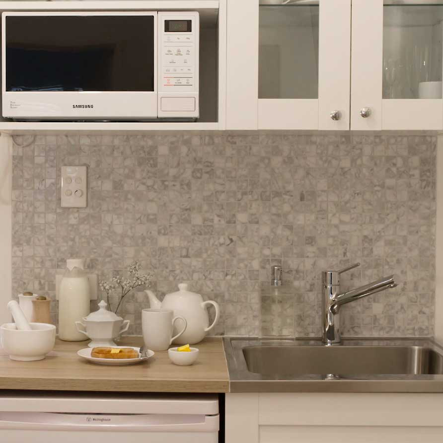 Kitchenette in Parkside Suite with microwave fridge and breakfast on the counter next to the large kitchen sink