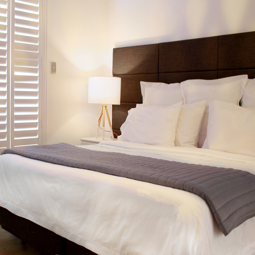 Turner Suite bedroom showing white plantation shutters and bedhead